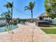 An inviting poolside deck with an outdoor kitchen, hot tub, and ample space for entertaining at 5623 Jobeth Dr, New Port Richey, FL 34652