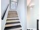 Bright staircase with stylish black and tan treads leading up to a window at 5623 Jobeth Dr, New Port Richey, FL 34652