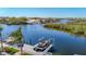 Beautiful waterfront view featuring a private boat lift and dock on a sunny day at 5623 Jobeth Dr, New Port Richey, FL 34652