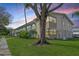 Multi-level condo featuring white exterior, stone accents, well-manicured lawn, and lush trees at 5850 21St N St # 12, St Petersburg, FL 33714