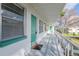 Inviting condo featuring a bright turquoise door, and a long covered walkway with white railings and neutral paint at 5850 21St N St # 12, St Petersburg, FL 33714