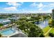 Expansive aerial view of a community pool, lush landscaping, and waterfront homes under a bright blue sky at 5940 Pelican Bay S Plz # 1105, Gulfport, FL 33707