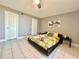 Bright bedroom featuring tile floors and an inviting yellow floral comforter and two doors at 5940 Pelican Bay S Plz # 1105, Gulfport, FL 33707