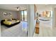 Bright bedroom featuring tile floors, ceiling fan, balcony access, and an inviting yellow floral comforter at 5940 Pelican Bay S Plz # 1105, Gulfport, FL 33707