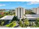 Beautiful exterior elevation showcasing a modern high-rise condominium building with well-manicured landscaping and ample parking at 5940 Pelican Bay S Plz # 1105, Gulfport, FL 33707