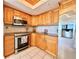 The kitchen features wooden cabinets, granite countertops, and stainless steel appliances at 5940 Pelican Bay S Plz # 1105, Gulfport, FL 33707