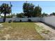 Large backyard with white vinyl fence, palm tree, gravel area, and view of the blue sky at 6221 13Th N Ave, St Petersburg, FL 33710