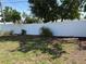 Grassy backyard with mature trees and a white vinyl fence, offering privacy and space at 6221 13Th N Ave, St Petersburg, FL 33710