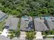Aerial view of a home with solar panels and a screened-in pool, nestled amongst lush trees in a suburban neighborhood at 6313 Brevada Ln, Apollo Beach, FL 33572