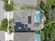 Bird's eye view of a home with solar panels, a screened-in pool, and manicured landscaping in a quiet community at 6313 Brevada Ln, Apollo Beach, FL 33572