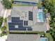 Aerial view of home with solar panels, a screened-in pool, and manicured landscaping in a lovely suburban community at 6313 Brevada Ln, Apollo Beach, FL 33572