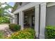 Inviting covered front porch with brick pavers, lush landscaping, and comfortable seating area at 6313 Brevada Ln, Apollo Beach, FL 33572