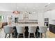 Elegant kitchen featuring a large island with seating, stainless steel appliances, and decorative lighting at 6313 Brevada Ln, Apollo Beach, FL 33572