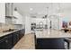Gourmet kitchen featuring sleek black and white cabinets, a spacious island, stainless appliances, and stylish pendant lighting at 6313 Brevada Ln, Apollo Beach, FL 33572