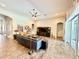 Open living room with a large media center, ceiling fan, and wood-look tile floors at 6313 Brevada Ln, Apollo Beach, FL 33572