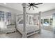 Airy main bedroom with a decorative four-poster bed, patterned tile floor, and ample natural light at 6313 Brevada Ln, Apollo Beach, FL 33572
