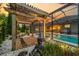 Relaxing backyard pool area with pergola, ambient lighting, and lush landscaping for a zen feel at 6313 Brevada Ln, Apollo Beach, FL 33572