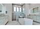 This primary bathroom offers dual sinks, a large tub, and a glass-enclosed shower at 684 Regatta Way, Bradenton, FL 34208