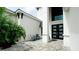 Modern exterior with a cozy patio area, adorned with stylish furniture, outside of the double-door entry at 684 Regatta Way, Bradenton, FL 34208