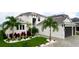 Beautiful two-story home featuring a three-car garage and professionally landscaped yard with palm trees at 684 Regatta Way, Bradenton, FL 34208