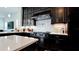 Gourmet kitchen boasts dark cabinetry, stainless steel appliances, and a stylish backsplash for a modern touch at 684 Regatta Way, Bradenton, FL 34208