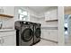 The bright laundry room features cabinets, countertops, a sink, and updated appliances at 684 Regatta Way, Bradenton, FL 34208