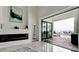 Elegant living room featuring modern fireplace, stylish decor, and sliding glass doors with a view of the pool at 684 Regatta Way, Bradenton, FL 34208