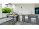 Outdoor kitchen with a grill, small refrigerator, sink, and storage space at 684 Regatta Way, Bradenton, FL 34208