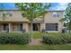A view of the back of the beige home with lush green grass and well-kept shrubs at 7029 White Treetop Pl, Riverview, FL 33578