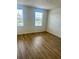 Bright bedroom with two windows offering natural light and beautiful wood-look flooring at 7029 White Treetop Pl, Riverview, FL 33578