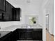 Contemporary kitchen with dark cabinets and stainless steel sink, flowing into an open floor plan at 7029 White Treetop Pl, Riverview, FL 33578