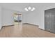Bright living room with hardwood floors, sliding glass doors, and a modern light fixture at 7029 White Treetop Pl, Riverview, FL 33578