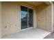 Open patio area with sliding glass door and beige exterior wall, perfect for outdoor relaxation at 7029 White Treetop Pl, Riverview, FL 33578