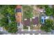 Aerial view shows house, fenced backyard, next to a house with a parking lot, and the street at 8505 N Brooks St, Tampa, FL 33604