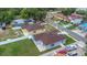 Overhead view showcasing light-blue home's brown roof, siding, manicured lawn, and concrete patio and driveway at 8505 N Brooks St, Tampa, FL 33604