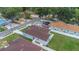 An aerial view showcasing a cozy, light-blue home featuring a well-maintained, grassy yard and a classic brown roof at 8505 N Brooks St, Tampa, FL 33604