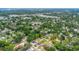 Aerial view shows the property amid a leafy neighborhood, featuring a parking area and manicured front lawn at 8505 N Brooks St, Tampa, FL 33604