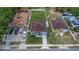 Aerial view showcases a light-blue home with well-kept lawn, surrounded by white fencing, and an ample parking area at 8505 N Brooks St, Tampa, FL 33604