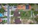 Aerial shot showing house, fenced backyard, next to a house with a parking lot, and the street at 8505 N Brooks St, Tampa, FL 33604