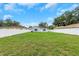 Green grass and a white fence with trees and houses in the background at 8505 N Brooks St, Tampa, FL 33604