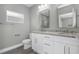 Modern bathroom featuring double sinks, granite countertops, and wood-look floors at 8505 N Brooks St, Tampa, FL 33604