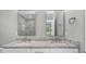 Modern bathroom features a double sink vanity with granite countertop, white cabinets, and rectangular mirrors at 8505 N Brooks St, Tampa, FL 33604