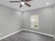 Bright bedroom with wood-look floors, ceiling fan, neutral walls, and a window view at 8505 N Brooks St, Tampa, FL 33604
