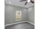 Bedroom showcasing modern ceiling fan, wood-look flooring, gray walls, and a window at 8505 N Brooks St, Tampa, FL 33604