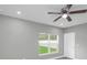 Cozy bedroom featuring a ceiling fan and a bright window with a view of the outdoors at 8505 N Brooks St, Tampa, FL 33604