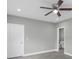 Comfortable bedroom with gray wood-look floors, a ceiling fan, and an en-suite bathroom at 8505 N Brooks St, Tampa, FL 33604