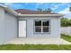 Rear view of the house showing siding, a door to the back yard, and concrete patio at 8505 N Brooks St, Tampa, FL 33604