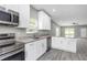 Open-concept kitchen with white cabinets and view to the living room at 8505 N Brooks St, Tampa, FL 33604