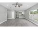 Open-concept living room with gray wood-look floors, ceiling fan, and bright natural light at 8505 N Brooks St, Tampa, FL 33604
