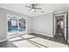 Bedroom featuring hardwood floors, a ceiling fan, and sliding door to the pool area at 8818 Poe Dr, Hudson, FL 34667